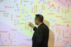 a South Bend Police Department employee pointing at a city map projected on the wall