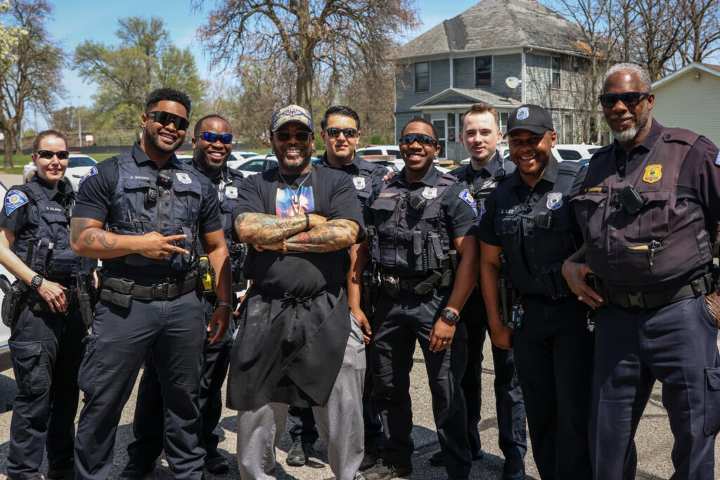 A group of SBPD officers poses with a local business owner in South Bend.