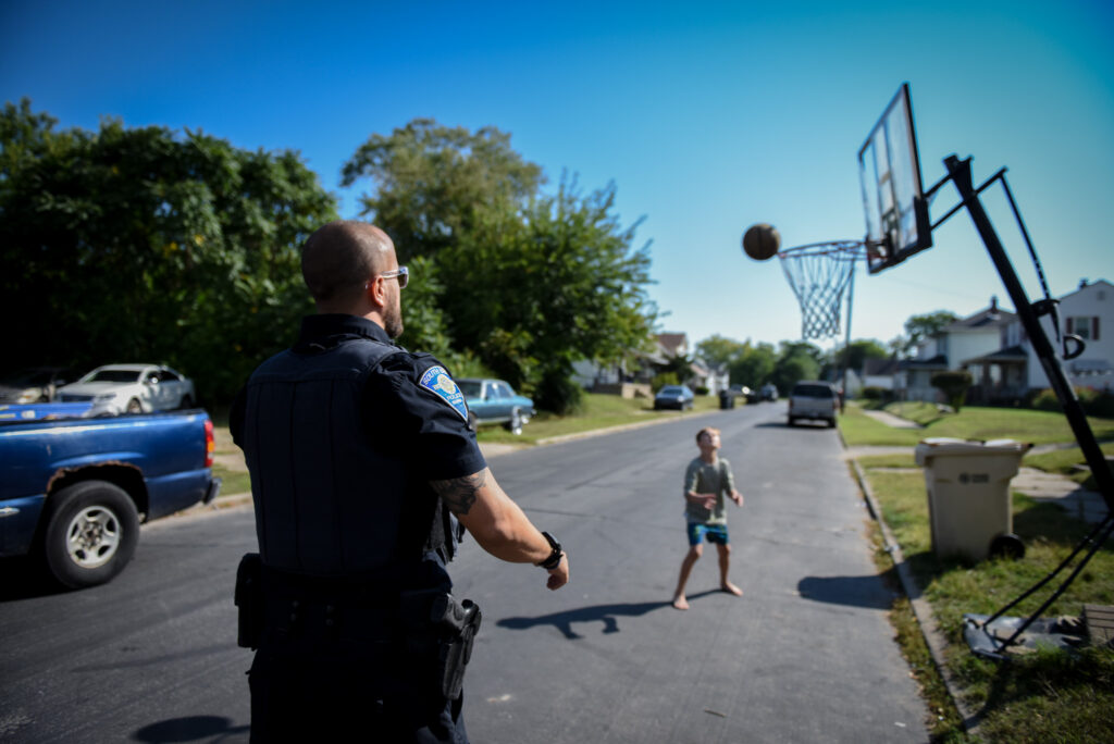an SBPD playing basketball with a child
